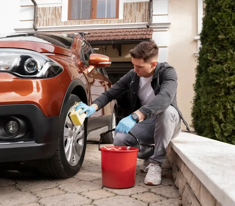 Lavage auto à domicile Saint-Quentin-la-Poterie : professionnel intervenant sur un véhicule